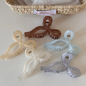 Detailed set of five ribbon bow claw clips in soft pastel colors and resin material