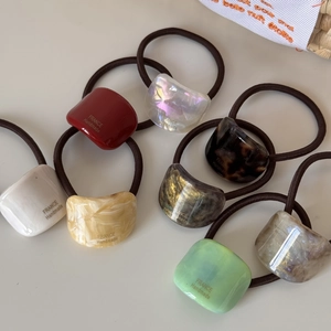 Detailed macro view of assorted French handmade acetate hair ties with gold accents