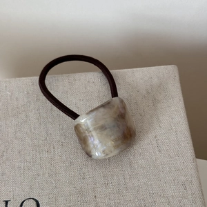 Close-up of handmade tortoiseshell acetate bead on high-elasticity hair tie