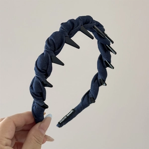 Detail of dark blue denim headband showing non-slip teeth and Hand Made label