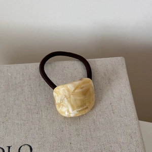 Detail of tortoise shell acetate charm with France Handmade text on elastic hair tie