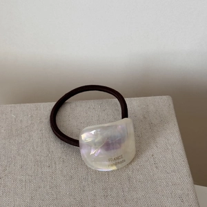 Close-up of iridescent acetate hair tie with France Handmade text and elastic band