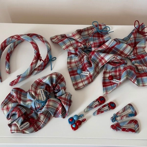 Flat lay of red and blue checkered hair accessories including bows and heart clips