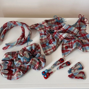 Detailed flat lay of red and blue plaid fabric hair accessories set on white background