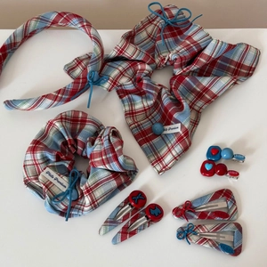 Detail view of 10-piece red and blue plaid fabric hair accessory set on white background
