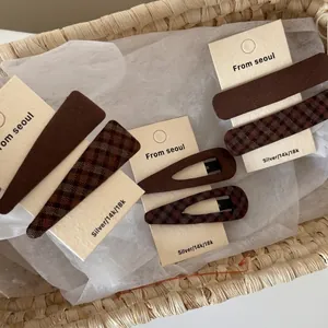 Vintage brown plaid fabric hair clips for women set in a rustic decorative woven basket