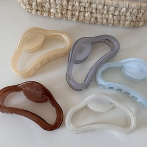 Vue de dessus de grandes pinces à cheveux couleur gelée en beige, gris, bleu et brun