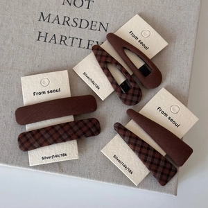 Detailed set of six brown plaid and solid fabric hair clips on white card display