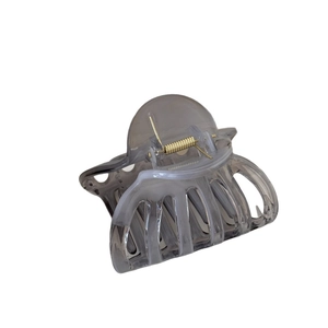 Pince à cheveux citrouille marbrée grise translucide avec ressort doré sur fond blanc