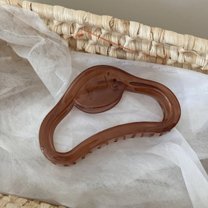 Détail de la pince à cheveux gelée marron café avec ressort métallique dans un panier