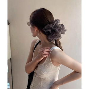 Leopard print mesh hair scrunchie for voluminous bun hairstyles on beige backdrop