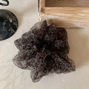 Macro shot of fluffy leopard print organza scrunchie with delicate pleats and mesh texture