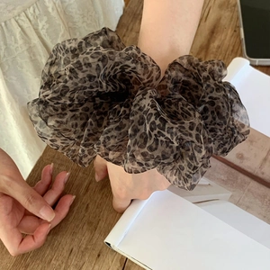 Detail of oversized leopard print mesh hair scrunchie with soft pleated texture