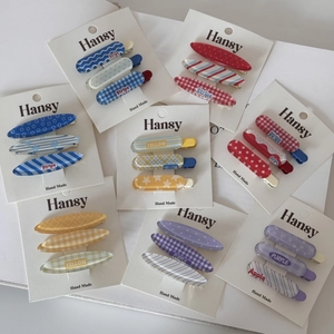 Vue à plat de lots de barrettes colorées style jelly avec motifs à pois et rayures