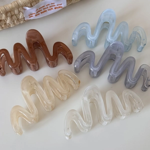 Five translucent acrylic hair claws in assorted colors like coffee and blue on white background
