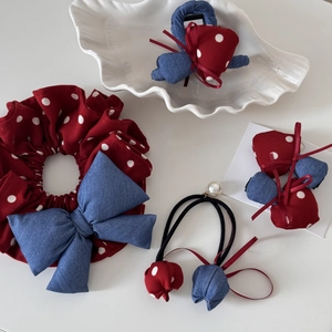 Close-up of red polka dot mushroom hair clips and blue denim bows on a white tray