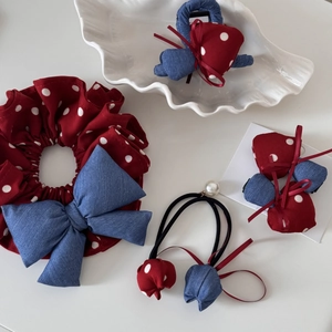 Detail of red polka dot hair accessories set with blue denim bows and pearl accents