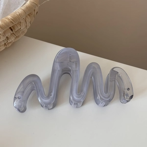 Detail of translucent grey-purple wavy hair claw clip with elegant marble texture
