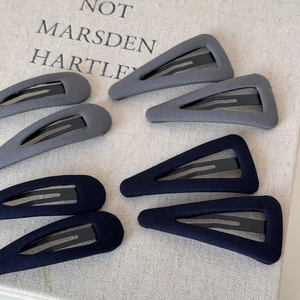 Close-up of grey and navy blue fabric triangle and teardrop hair clips set