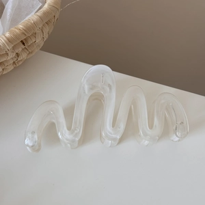 Macro detail of high-quality resin hair claw with wavy translucent white texture