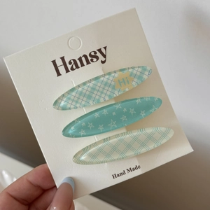 Détail de trois barrettes à cheveux colorées à carreaux sur une carte faite à la main