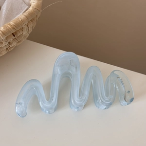 Close-up of light blue marble textured resin hair claw clip with wave design