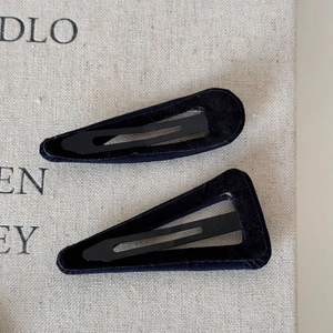 Detail view of black fabric-covered geometric triangle and drop-shaped hair clips