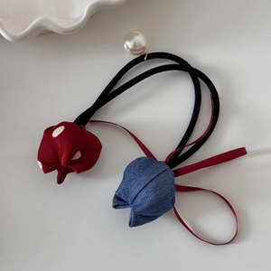 Detail of tulip hair tie with red polka dot and blue denim fabric charms and pearl