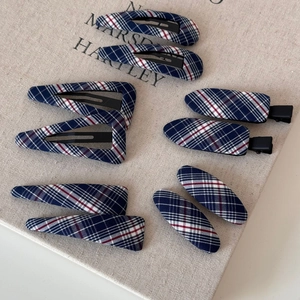 Detail view of 10-piece navy plaid hair clip set with various geometric shapes and fabric texture