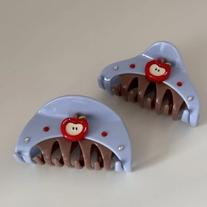 Detailed macro view of lilac shark hair clip featuring red apple and sparkling rhinestones