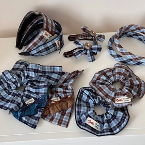 Vue à plat d'accessoires de cheveux à carreaux bleus et bruns avec chouchous et serre-têtes