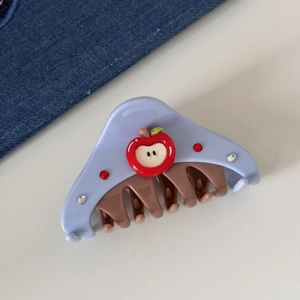 Detail of Korean style hair claw clip with blue body and red apple rhinestone design