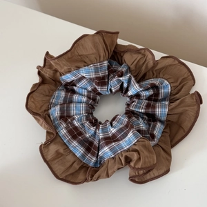 Détail de la texture du tissu à carreaux marron et bleu de ce chouchou à multicouches