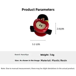Detail showing red apple hair clip dimensions 3.2cm x 2.6cm and plastic material specs