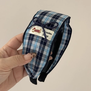 Vue détaillée du serre-tête en tissu à carreaux bleus avec écusson chien mignon et nœud