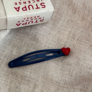 Barrette BB bleu foncé avec cœur rouge 3D sur fond de lin et boîte blanche