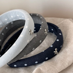 Macro view of polka dot sponge headbands with small silver metal bows in three colors