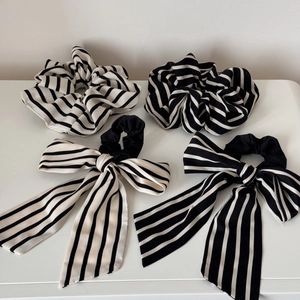 Set of four black and white striped scrunchies and bow hair ties for elegant styling