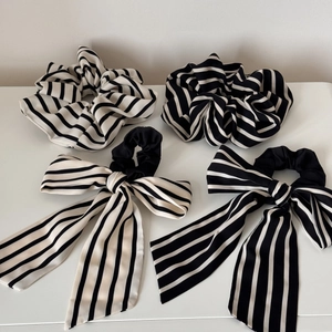 Detail view of four-piece black and white striped scrunchies set with elegant long ribbons