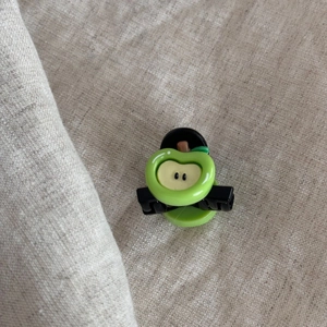Detail of mini green apple hair claw clip featuring realistic fruit slice texture