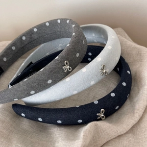 Close-up of padded polka dot headbands with metallic silver bow detail and soft fabric