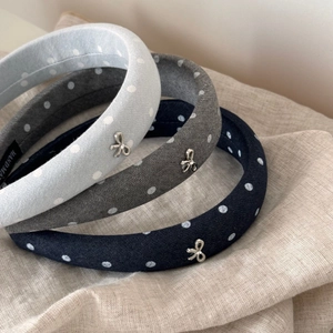 Close-up of three polka dot headbands with silver metal bows and crystal detailing