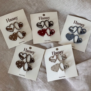 Detailed view of heart-shaped hair clips in various patterns on a card packaging