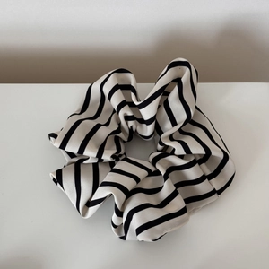 Detail of a large oversized scrunchie featuring classic black and white stripes