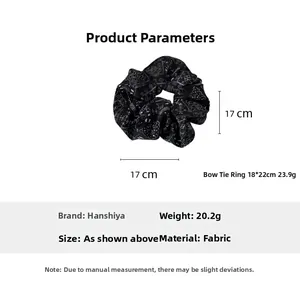 Detail view of a 17cm oversized black fabric scrunchie with white paisley pattern