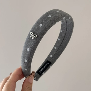 Detail of grey polka dot sponge headband with silver bow and hand made label
