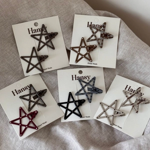 Set of ten star-shaped hair clips with polka dots and patterns on display card