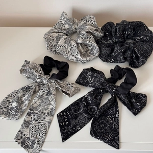 Detailed set of four paisley pattern scrunchies and bow hair ties in black and white