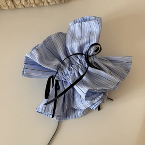 Detail of blue striped scrunchie with a black bow in balletcore style for buns