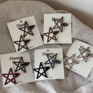 Detail of star-shaped hair clips with polka dots and plaid patterns on display cards